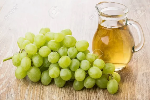 81219598-bunch-of-white-grapes-and-jug-of-grape-juice-on-wooden-table
